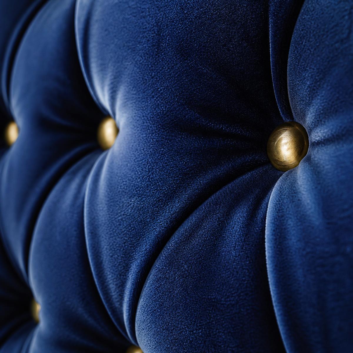 Macro detail of royal navy diamond-tufted velvet upholstery with brass buttons